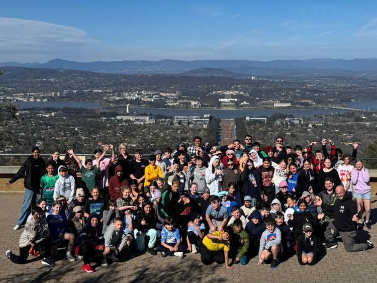 A large group photo of our stage 3 students at a look out in Canberra seeing Parliment house in background.