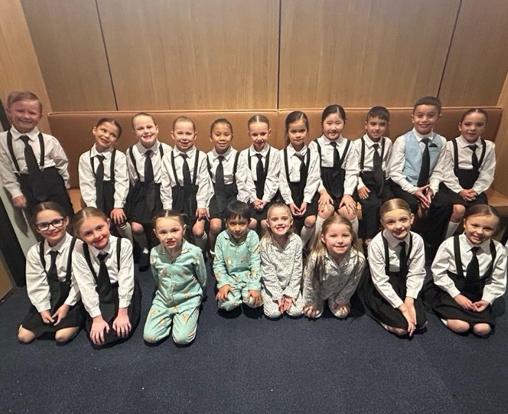 A group photo of students who performed in the dance group. Students are dressed in a tie and suspenders.